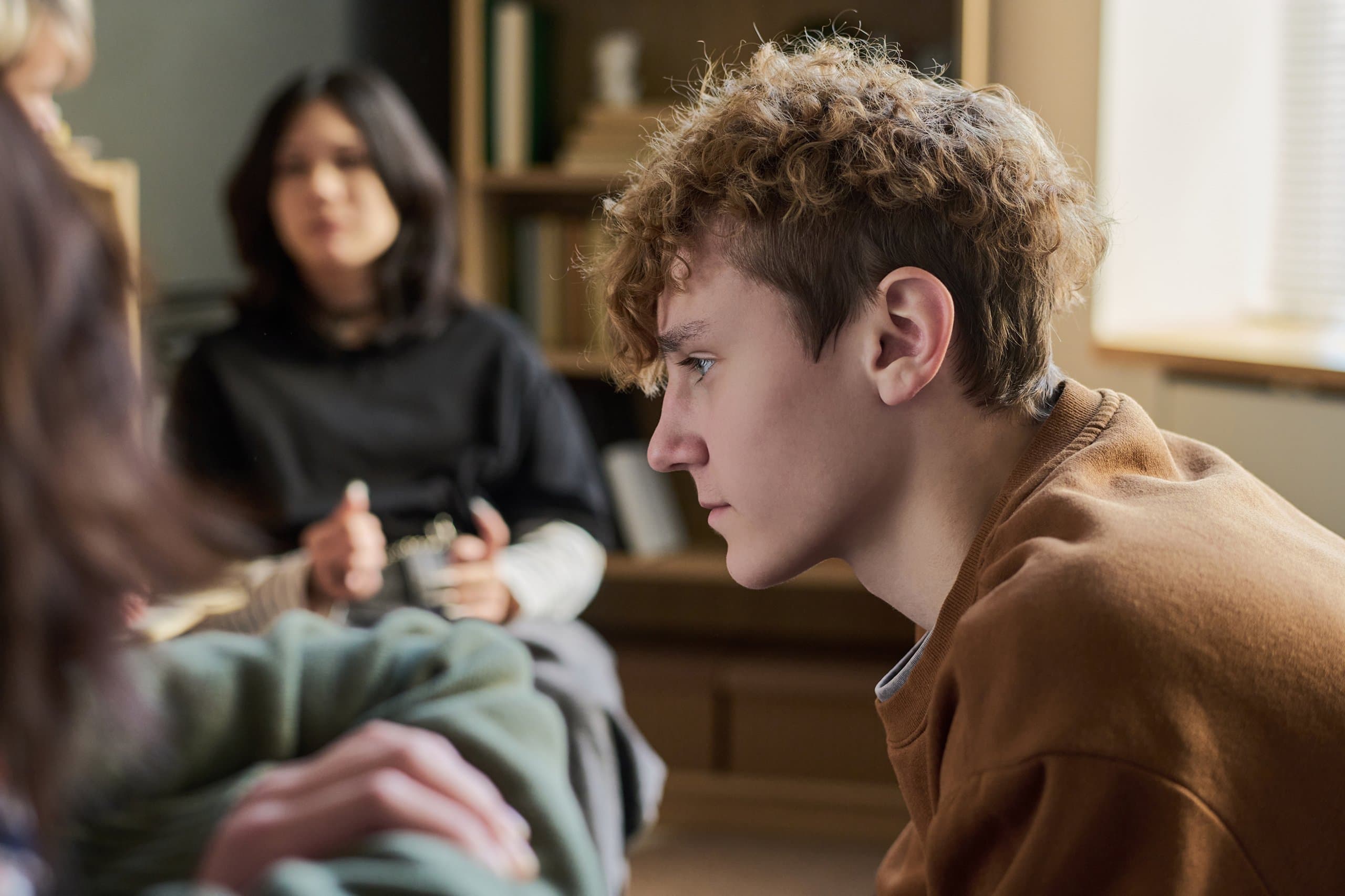solemn young man sitting listening