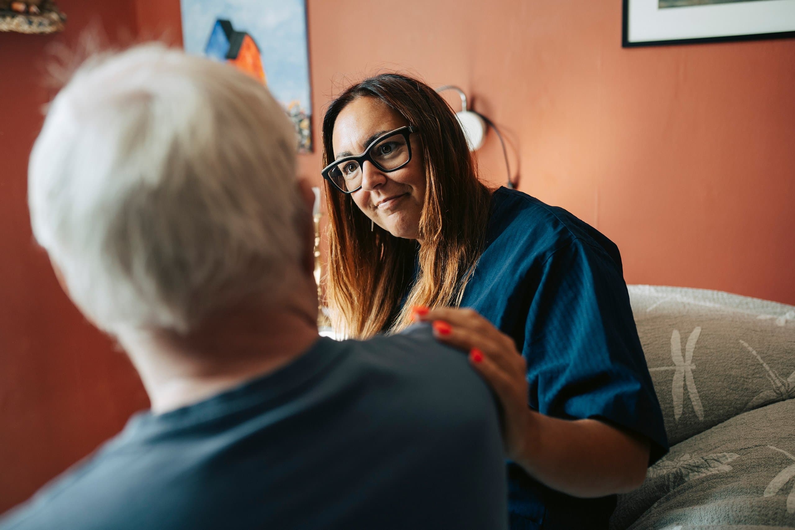 care giver sits with and listens to elderly